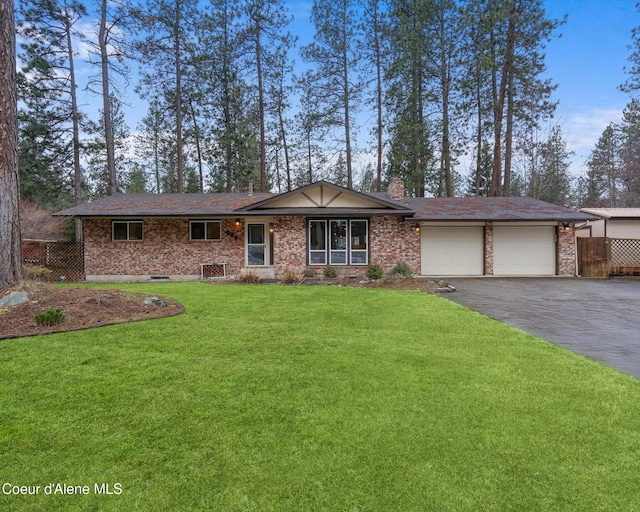 ranch-style home with a garage, a chimney, aphalt driveway, fence, and a front yard