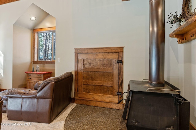 interior space featuring a wood stove, vaulted ceiling, and recessed lighting