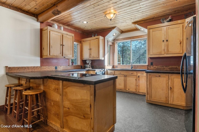 kitchen featuring wooden ceiling, a peninsula, a sink, black appliances, and dark countertops