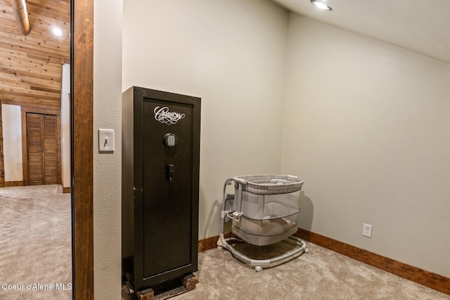 interior space with baseboards, vaulted ceiling, and carpet flooring