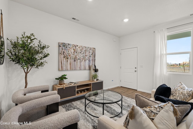 living area with baseboards, visible vents, wood finished floors, and recessed lighting