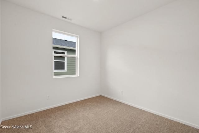 carpeted spare room with visible vents and baseboards