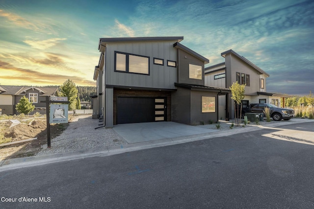 view of front of property featuring board and batten siding, concrete driveway, and a garage