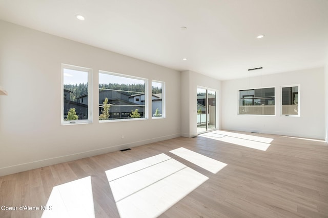 spare room with light wood finished floors, visible vents, baseboards, and recessed lighting