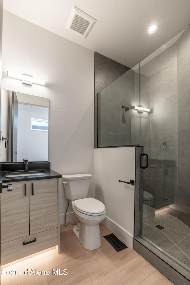 bathroom with toilet, a shower stall, and visible vents