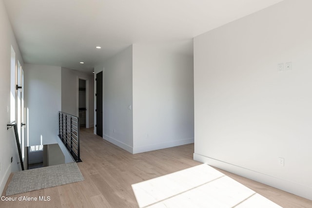 unfurnished room with recessed lighting, wood finished floors, and baseboards