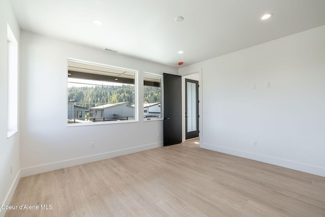 spare room featuring recessed lighting, wood finished floors, visible vents, and baseboards