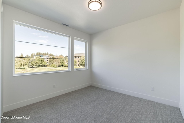 carpeted empty room with visible vents and baseboards