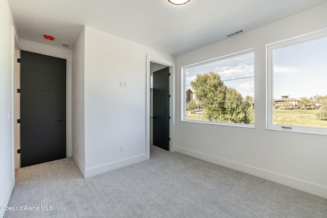 unfurnished bedroom with carpet flooring, visible vents, and baseboards