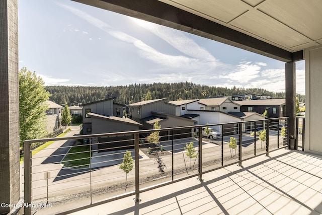 balcony with a residential view and a view of trees