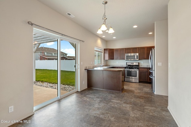 kitchen featuring stainless steel appliances, hanging light fixtures, an inviting chandelier, a sink, and a peninsula