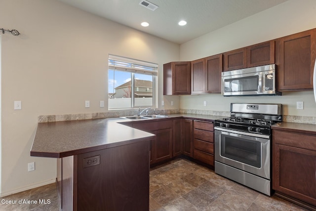 kitchen with visible vents, appliances with stainless steel finishes, a peninsula, a sink, and recessed lighting