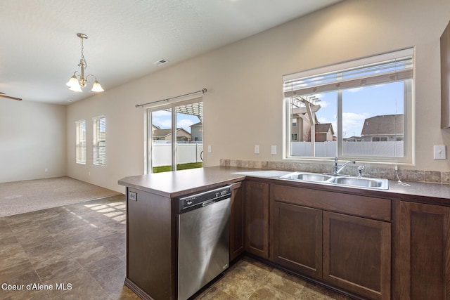 kitchen featuring visible vents, washer and clothes dryer, dishwasher, pendant lighting, and a sink