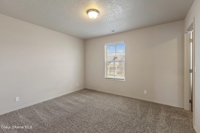 unfurnished room featuring carpet, visible vents, a textured ceiling, and baseboards