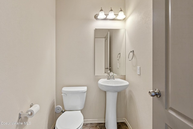 bathroom featuring a sink, toilet, and baseboards