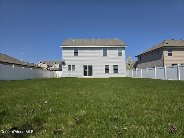 back of house with fence and a lawn