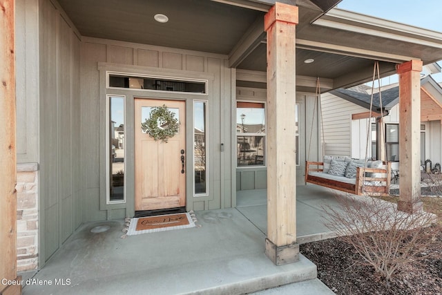 property entrance with covered porch and board and batten siding