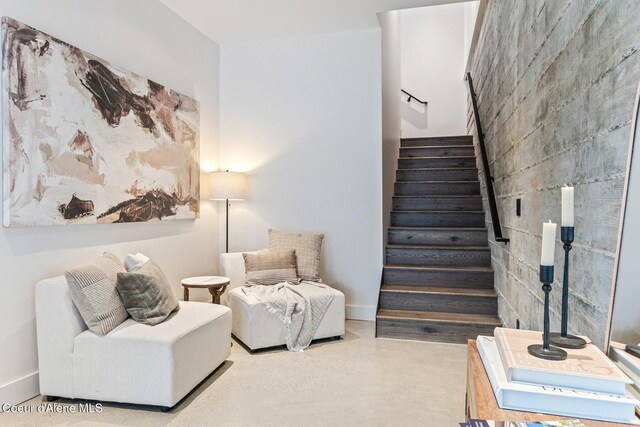 living area featuring stairs and baseboards