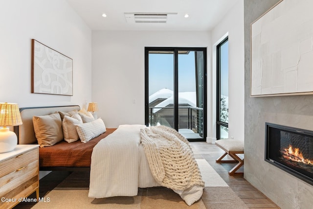 bedroom featuring recessed lighting, a large fireplace, visible vents, light wood-style floors, and access to outside