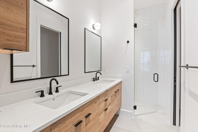 bathroom featuring double vanity, tile patterned flooring, a sink, and a shower stall