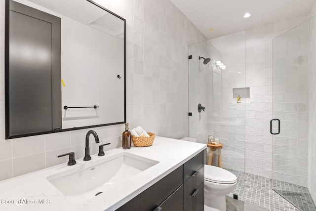 full bathroom featuring toilet, vanity, tile walls, backsplash, and a stall shower