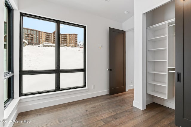 unfurnished bedroom with baseboards and dark wood finished floors