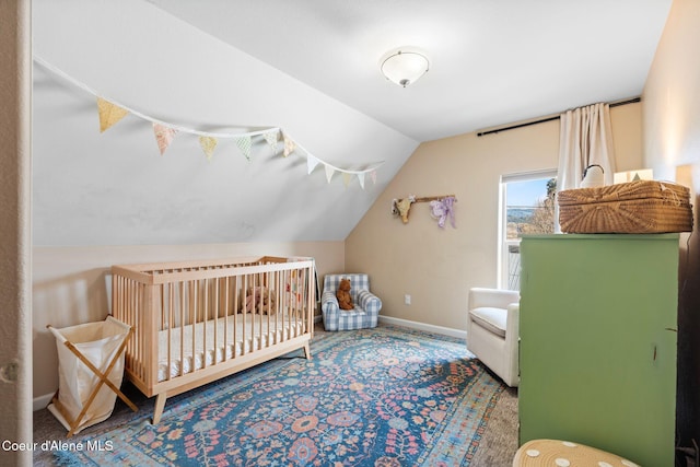 bedroom with a nursery area, baseboards, vaulted ceiling, and carpet flooring