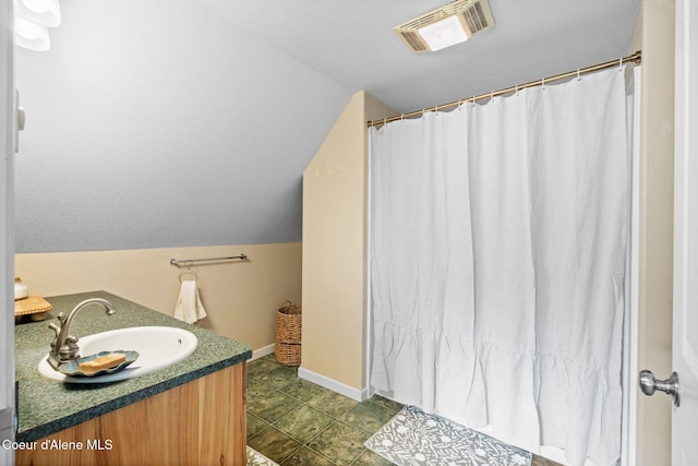 full bath featuring a shower with shower curtain, vanity, visible vents, vaulted ceiling, and baseboards