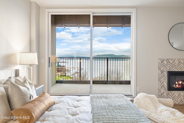 bedroom with access to outside and a fireplace