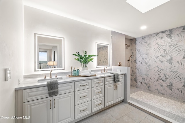 full bath with a tile shower, double vanity, tile patterned flooring, and a sink