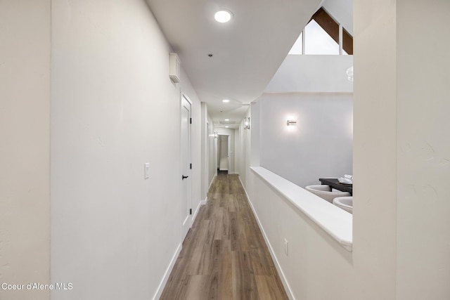 hall with baseboards, wood finished floors, and recessed lighting