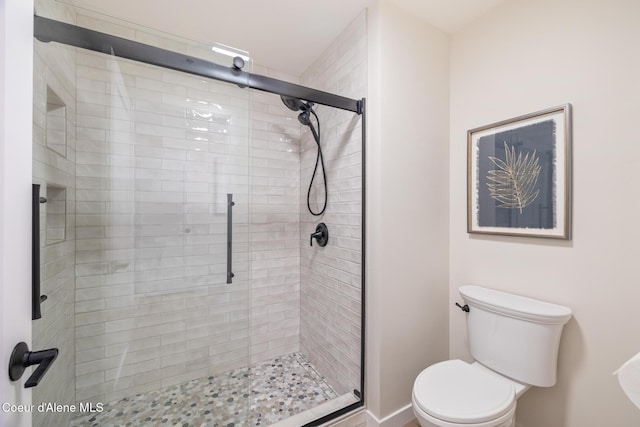 bathroom featuring a shower stall and toilet