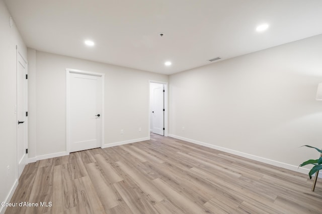 spare room with recessed lighting, light wood-type flooring, visible vents, and baseboards