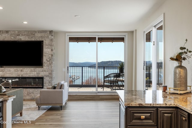 301 N 1st St # 930, Coeur Dalene, ID 83814 - living area featuring a large fireplace, a water view, recessed lighting, and light wood-style flooring