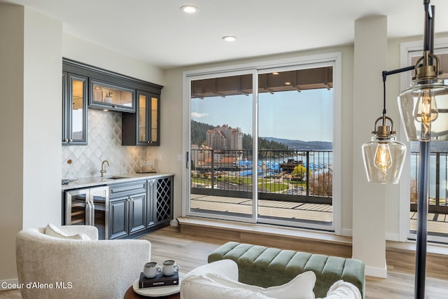301 N 1st St # 930, Coeur Dalene, ID 83814 - interior space with wet bar, decorative backsplash, light wood-type flooring, and beverage cooler