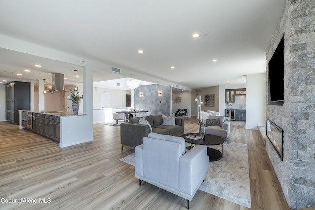 301 N 1st St # 930, Coeur Dalene, ID 83814 - living area featuring recessed lighting, visible vents, a stone fireplace, and light wood-style flooring