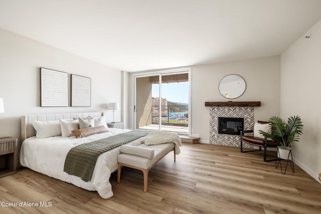 301 N 1st St # 930, Coeur Dalene, ID 83814 - bedroom featuring baseboards, access to outside, light wood-style flooring, and a tile fireplace