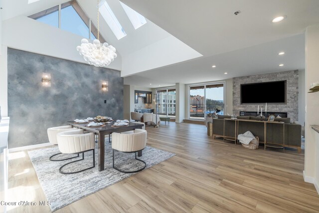 301 N 1st St # 930, Coeur Dalene, ID 83814 - dining room featuring a skylight, wood finished floors, a chandelier, an accent wall, and recessed lighting