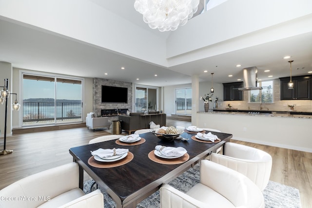 301 N 1st St # 930, Coeur Dalene, ID 83814 - dining space featuring an inviting chandelier, a fireplace, recessed lighting, and wood finished floors