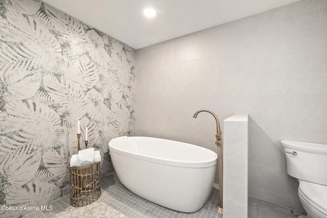 301 N 1st St # 930, Coeur Dalene, ID 83814 - full bath featuring a freestanding tub, tile patterned floors, toilet, and tile walls
