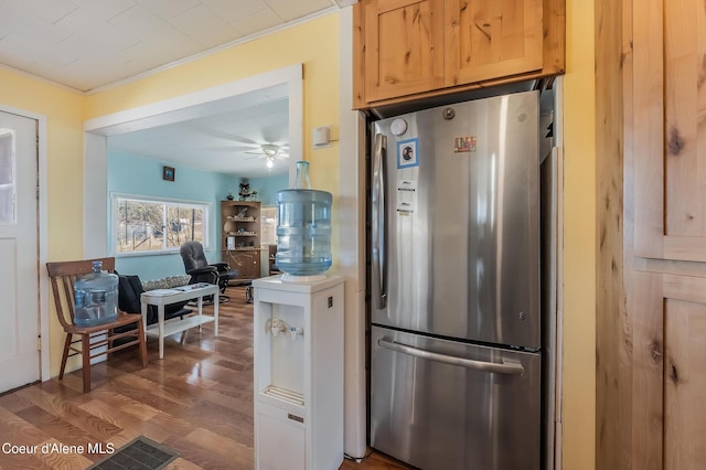 kitchen featuring ceiling fan, freestanding refrigerator, crown molding, and wood finished floors