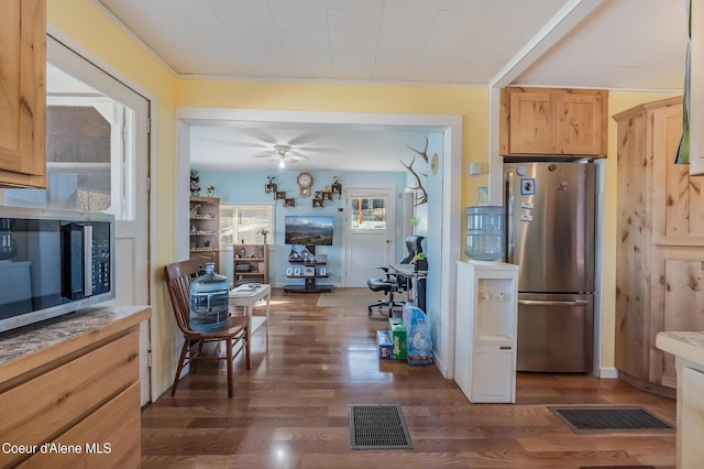 kitchen featuring appliances with stainless steel finishes, visible vents, dark wood-type flooring, and light brown cabinetry