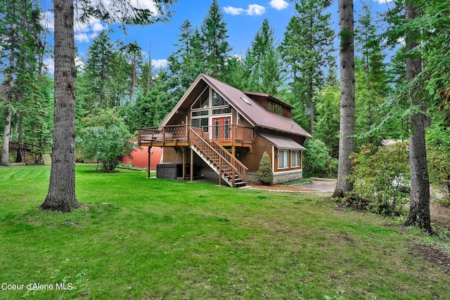 back of property with stairs, a yard, metal roof, and a wooden deck