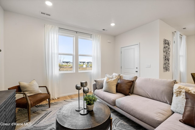 living room featuring baseboards, recessed lighting, visible vents, and light wood-style floors