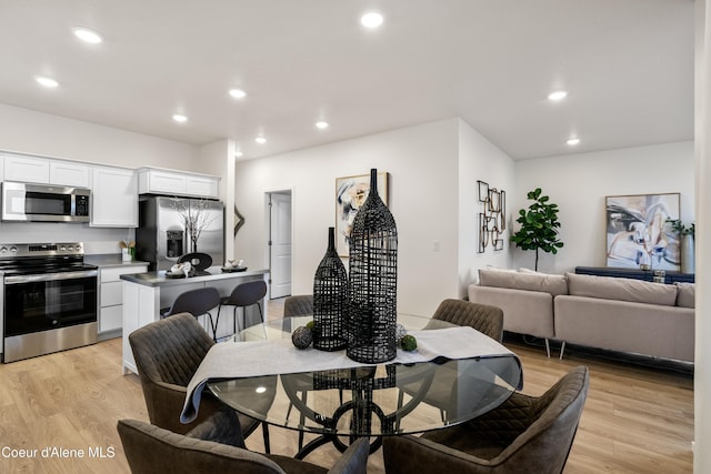 dining space with recessed lighting and light wood finished floors