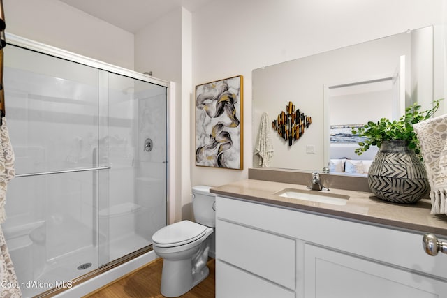 full bath with toilet, a shower stall, vanity, and wood finished floors