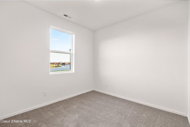 spare room with baseboards, visible vents, and carpet flooring