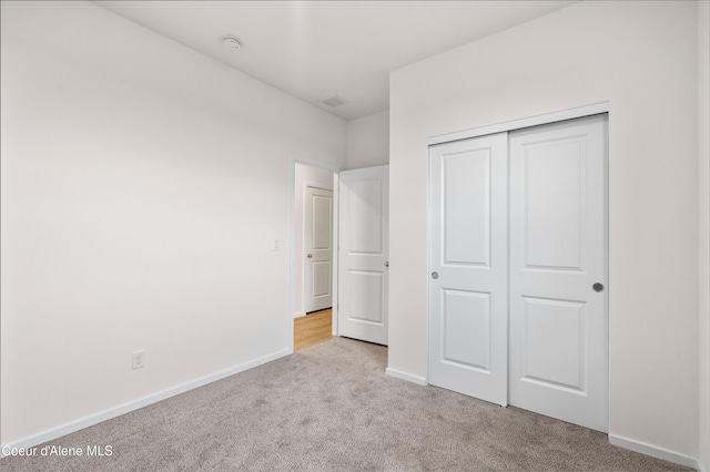 unfurnished bedroom featuring carpet floors, baseboards, and a closet