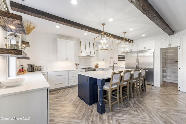1853 W Felton Dr, Coeur Dalene, ID 83814 - kitchen featuring built in appliances, custom exhaust hood, tasteful backsplash, beamed ceiling, and a center island with sink