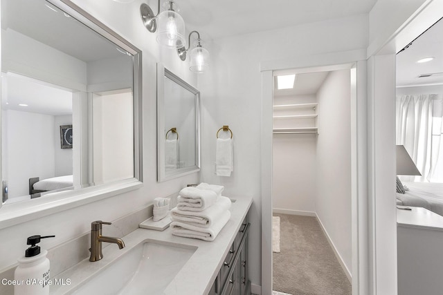 1853 W Felton Dr, Coeur Dalene, ID 83814 - ensuite bathroom featuring a walk in closet, connected bathroom, vanity, and baseboards